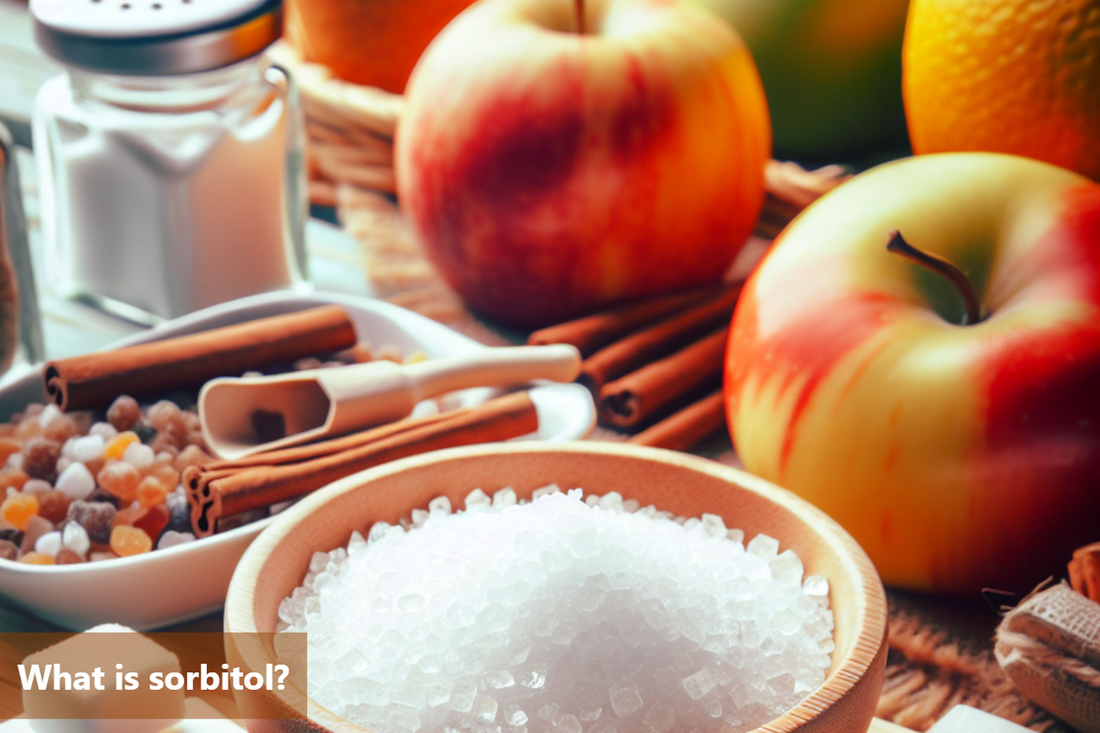 A wooden bowl filled with sorbitol crystals. In the background are apples and cinnamon sticks.