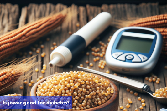 A bowl of jowar grains, a glass of green tea, and a blood sugar monitor on a wooden table.