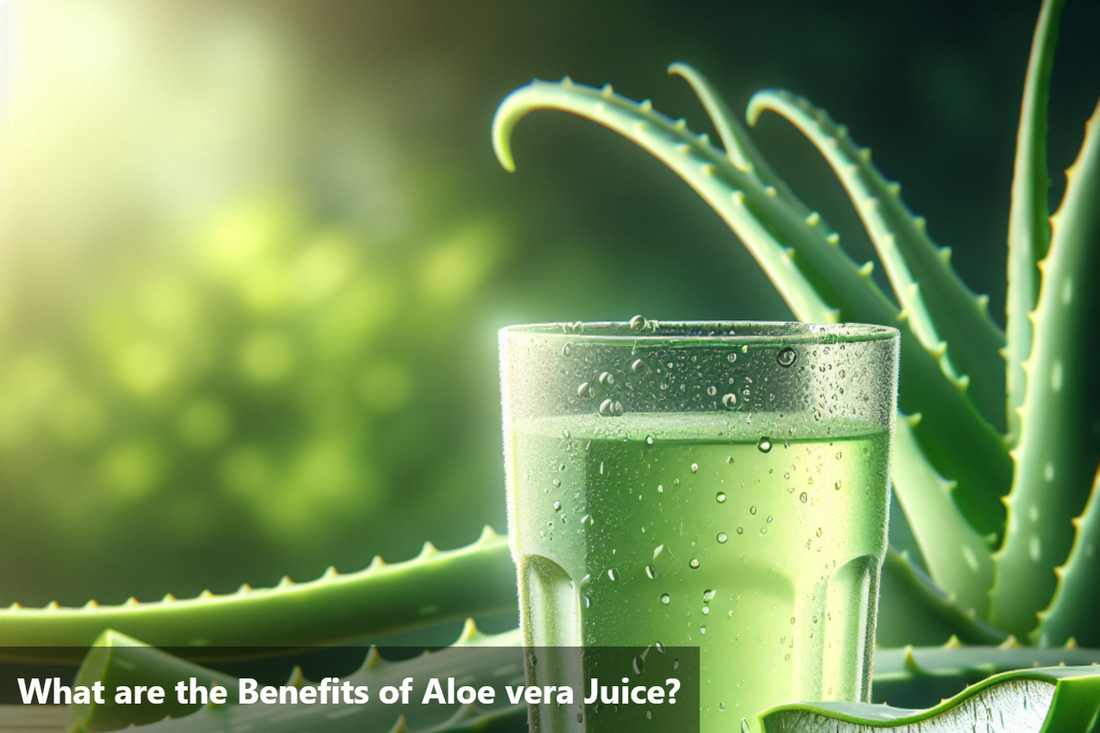 A glass of aloe vera juice with fresh aloe vera leaves on a wooden table.