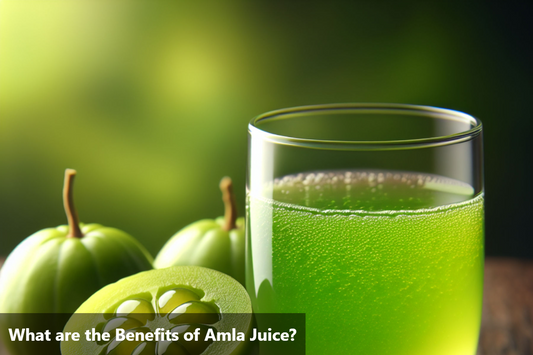 A glass of amla juice next to a bowl of amla fruits.